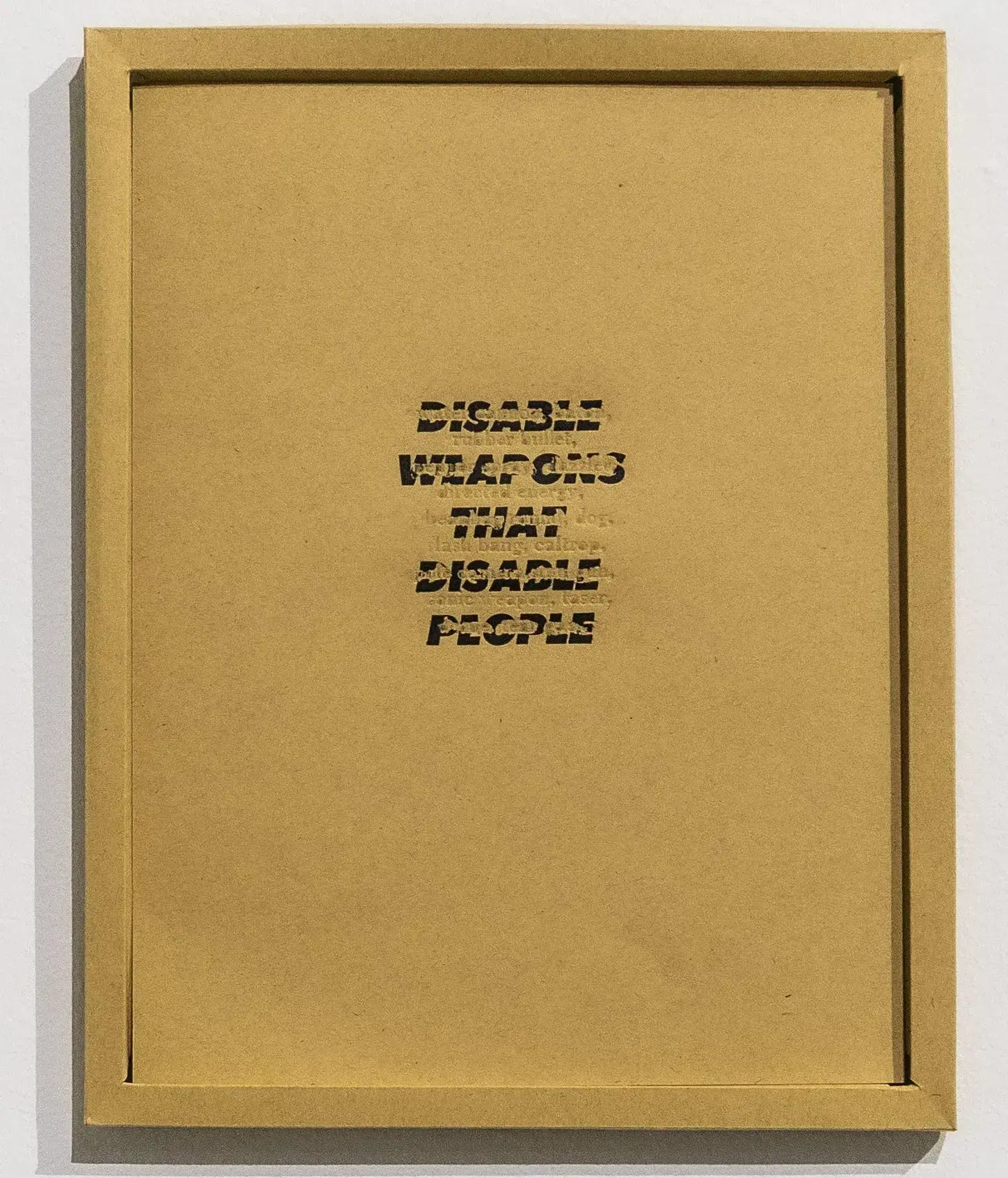 A piece of paper in a paper frame a bit larger than a regular eight and a half by eleven. Words are letter pressed into the paper creating negative space against text in ink. Disabled weapons that disabled people. A piece of paper in a paper frame a bit larger than a regular eight and a half by eleven. Words are letter pressed into the paper creating negative space against text in ink. Disabled weapons that disabled people.