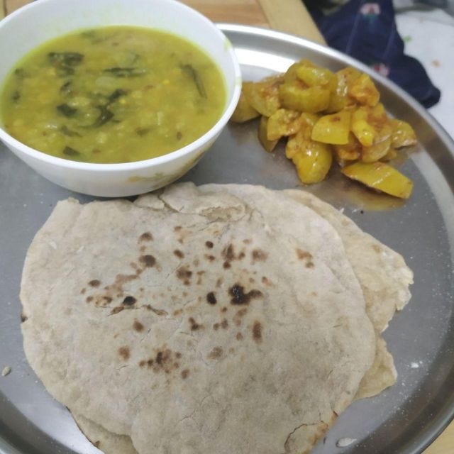 A plate of rotis with dal and lauki