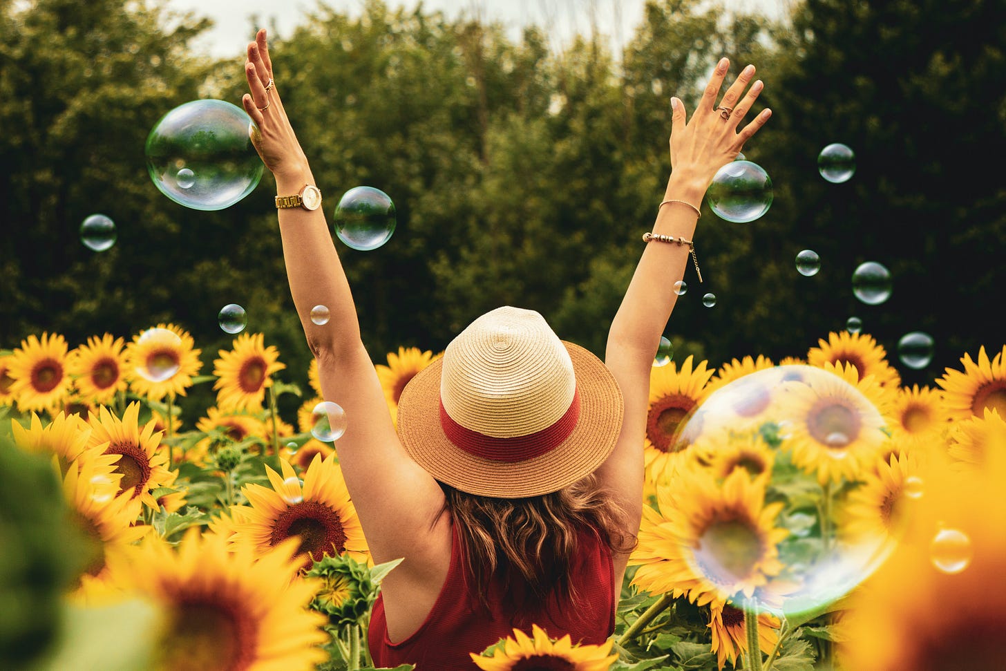 Woman in field of sunflowers with bubbles