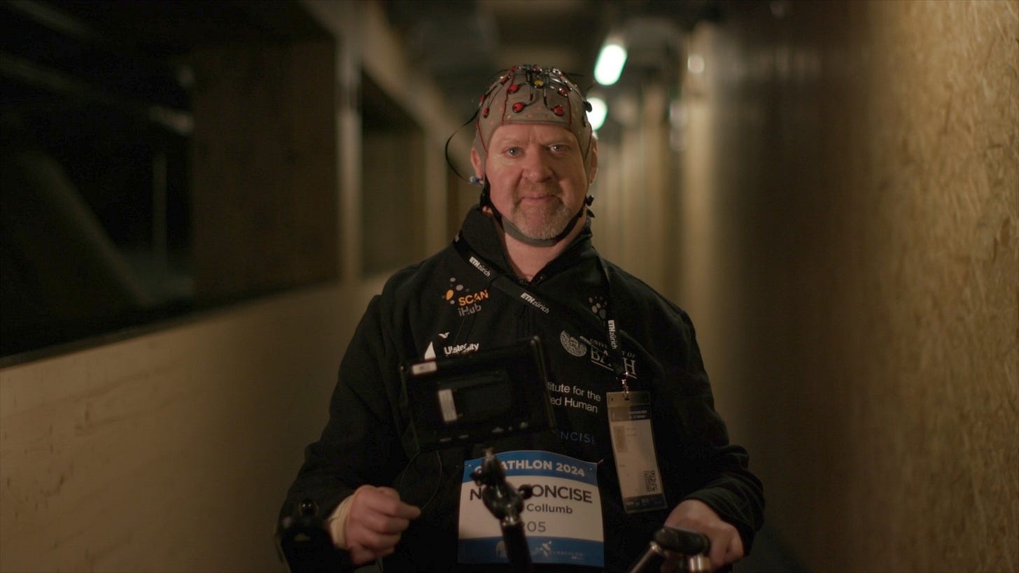 A man in a wheelchair wearing a cap with electrodes attached