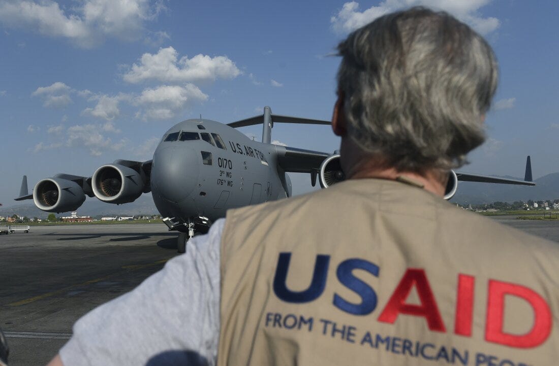 A USAID officer watches as a US military C-17 cargo plane taxis to a stop at Kathmandu's international airport on May 3, 2015. International aid continues to pour into Nepal to help victims of a massive earthquake on April 25 killed at least 7,200 people and devastated vast swathes of one of Asia's poorest countries.
