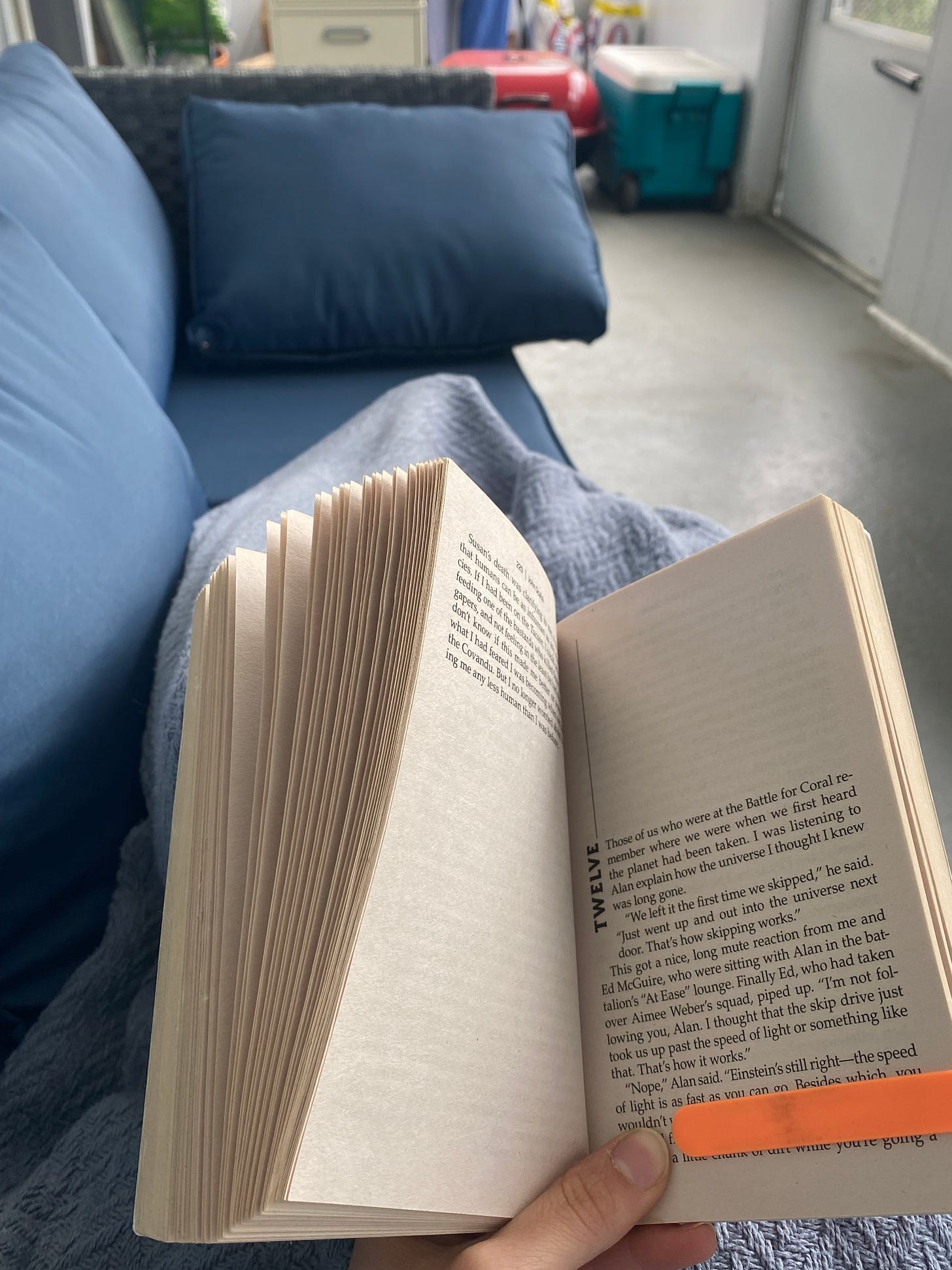 Someone reading a book on a porch.