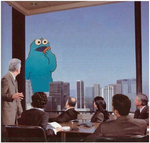 This may contain: a man standing in front of a group of people sitting around a conference room table