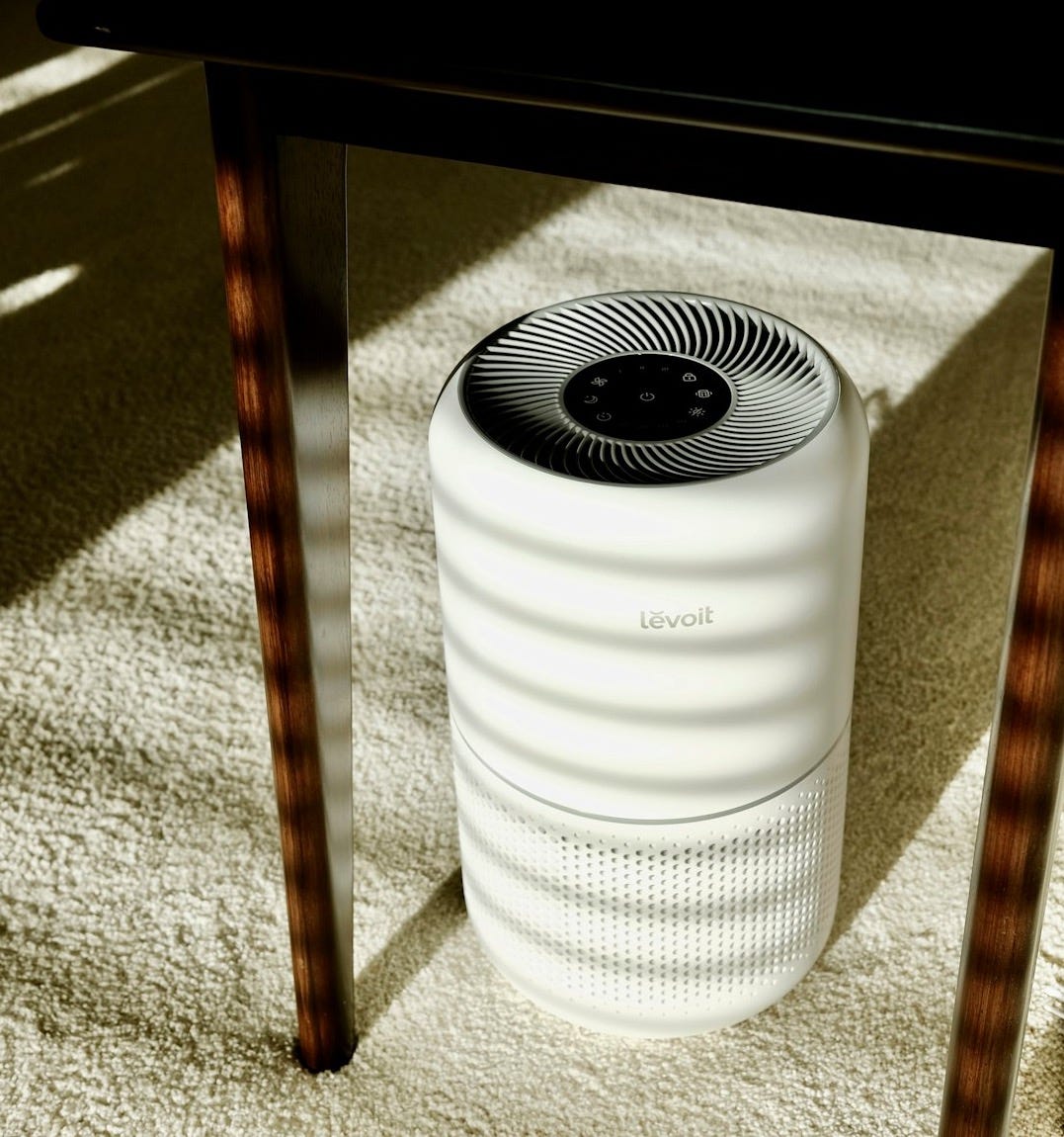 a white air conditioner sitting under a table