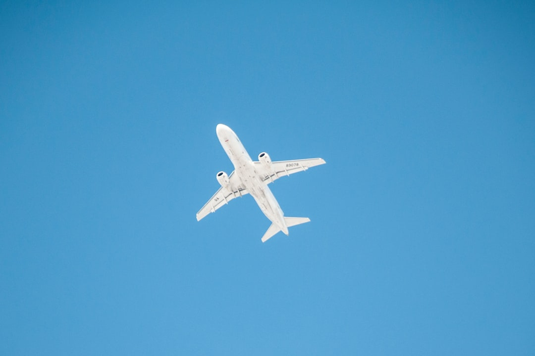 white airplane in mid air during daytime