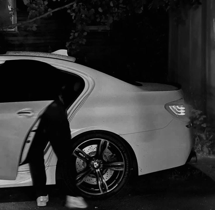 This may contain: a man in a suit stepping out of a white car