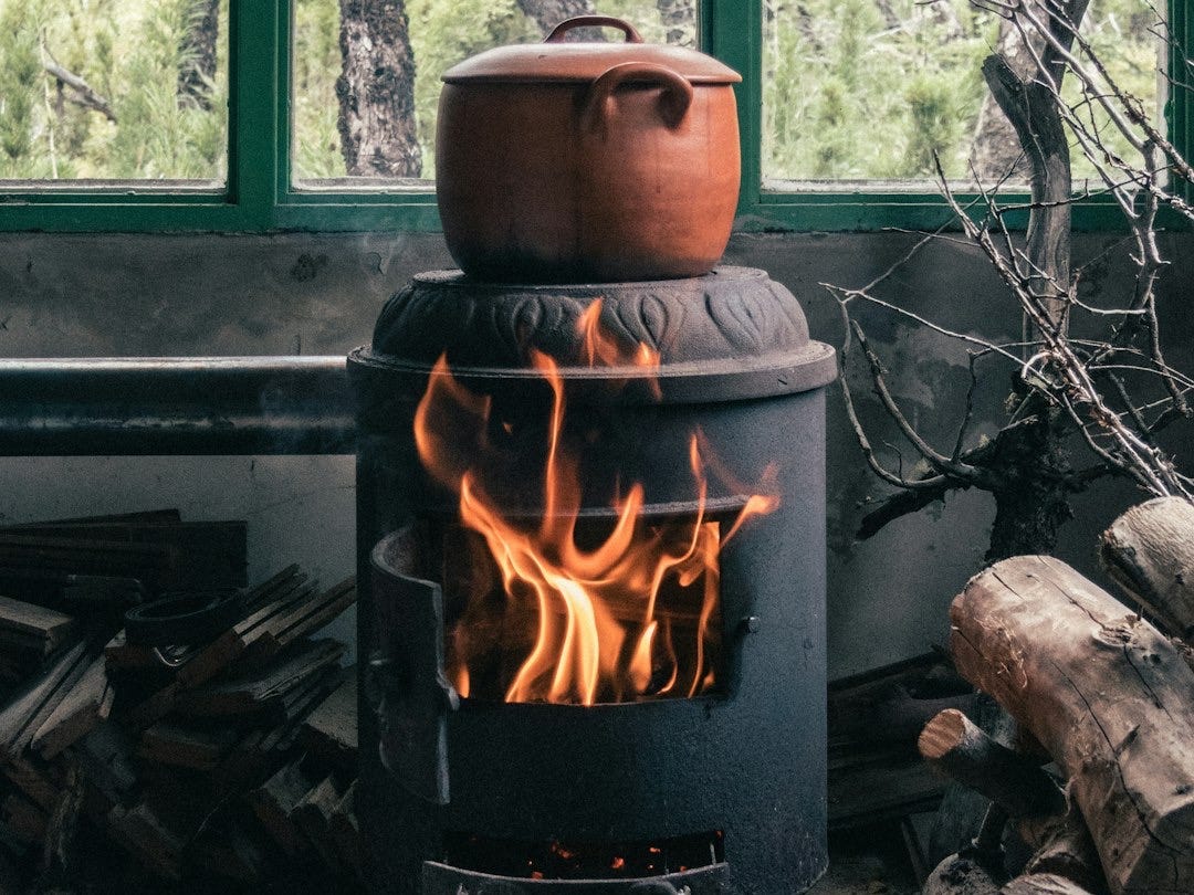 brown clay pot on black wood burner brown clay pot on black wood burner