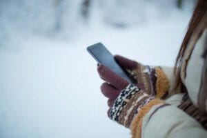 mittens holding a phone