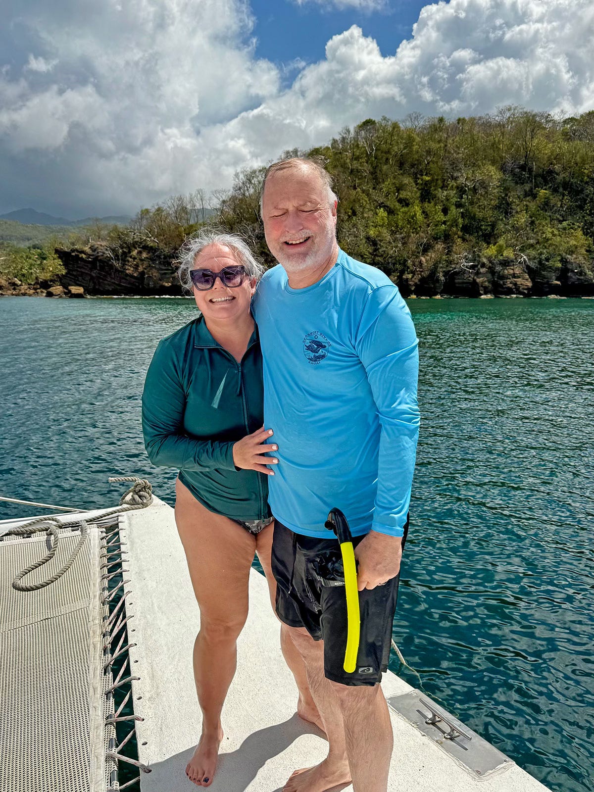 Woman and man standing on a boat in Grenada wearing swim gear after snorkeling