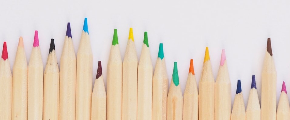 colored pencil lined up on top of white surface
