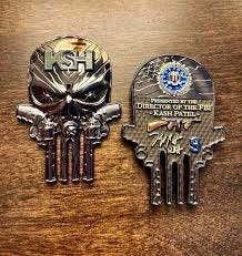 FBI Director Kash Patel is giving out his own custom-designed challenge  coins to his top guys. They've got the Punisher skull, spiders, big iron  revolvers—and stamped right on the front is “K$H.”