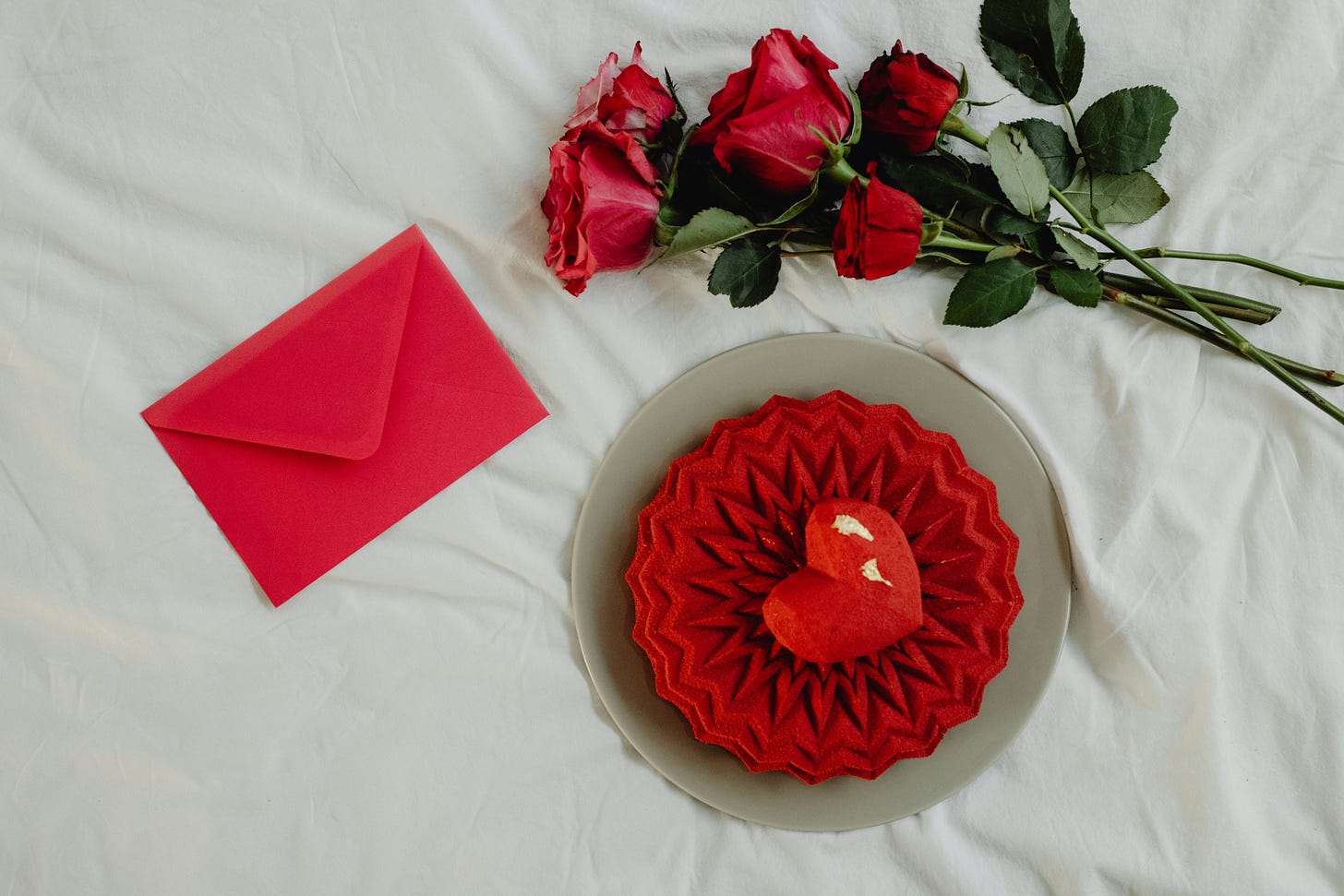red roses, envelope and cake