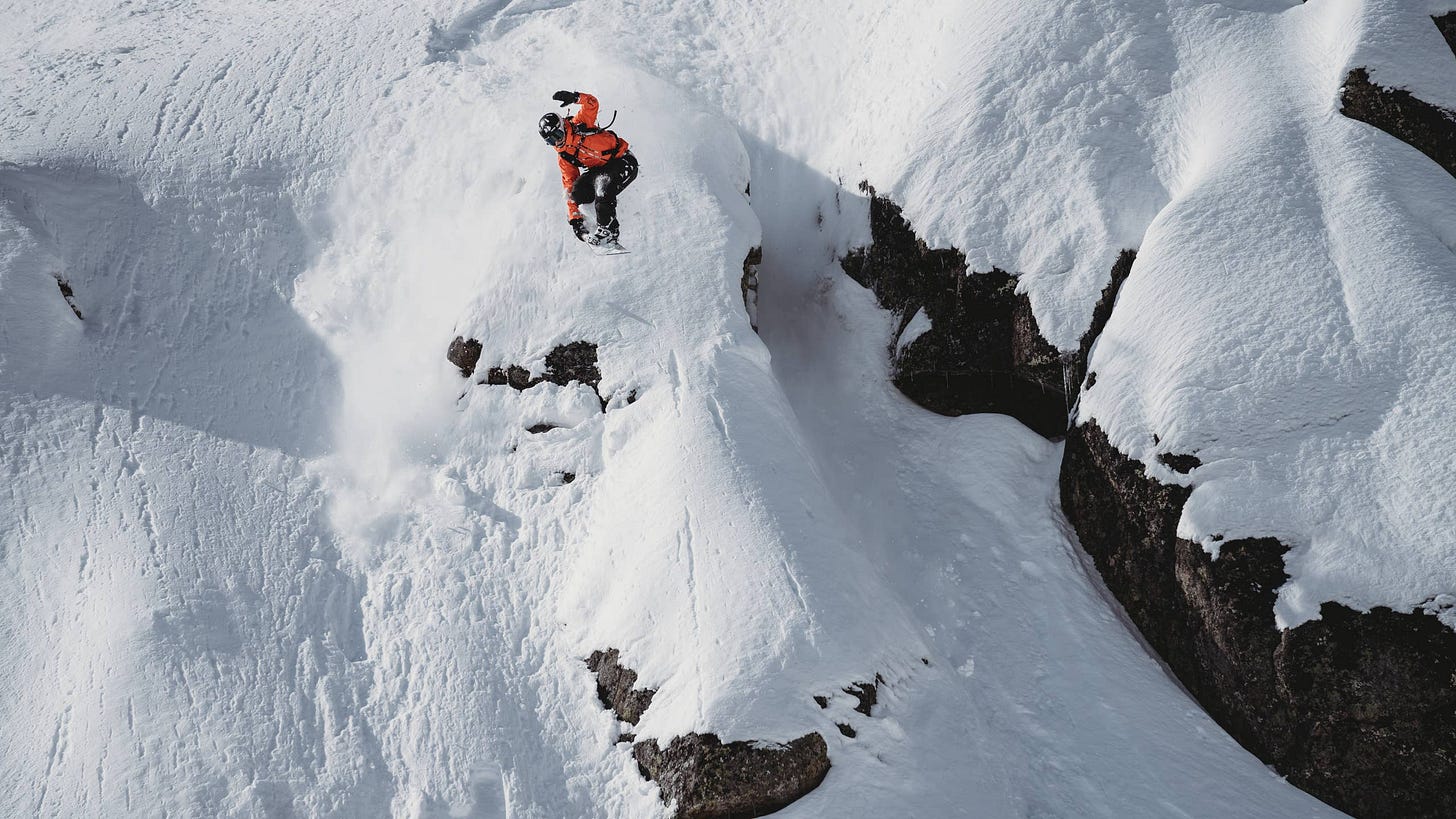 Mia Jones drops a massive cliff in deep snow. Mia Jones drops a massive cliff in deep snow.