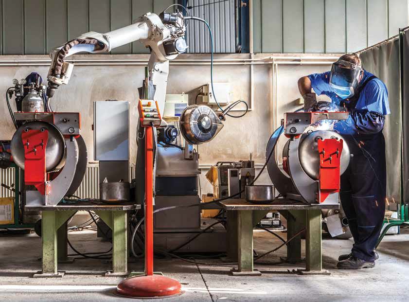 A robot and a human work together. A real photo from a real factory. A robot and a human work together. A real photo from a real factory.
