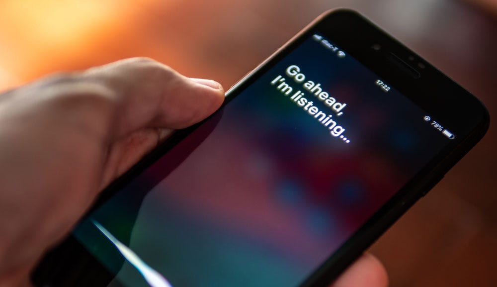 Siri presenting 'Go ahead, I'm listening' in text on iPhone screen. Siri presenting 'Go ahead, I'm listening' in text on iPhone screen.