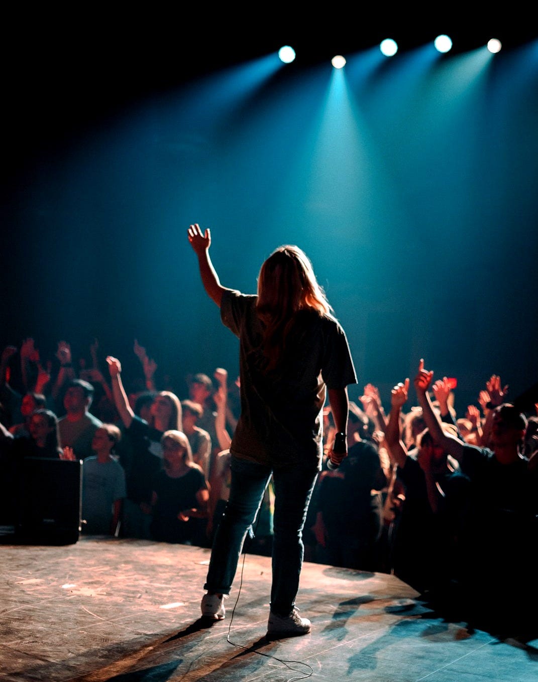 woman in black jacket standing on stage woman in black jacket standing on stage