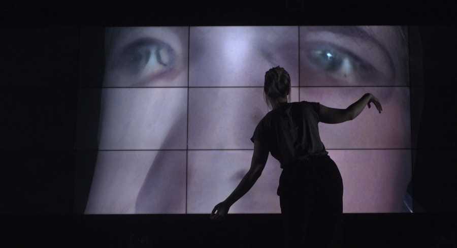 Work-in-progress preview of SELF ABSORBED by Tim Murray-Browne. A woman stands in front of a large video wall striking a pose with her arms. On the video wall is a 3D render of a distorted male face. Work-in-progress preview of SELF ABSORBED by Tim Murray-Browne. A woman stands in front of a large video wall striking a pose with her arms. On the video wall is a 3D render of a distorted male face.