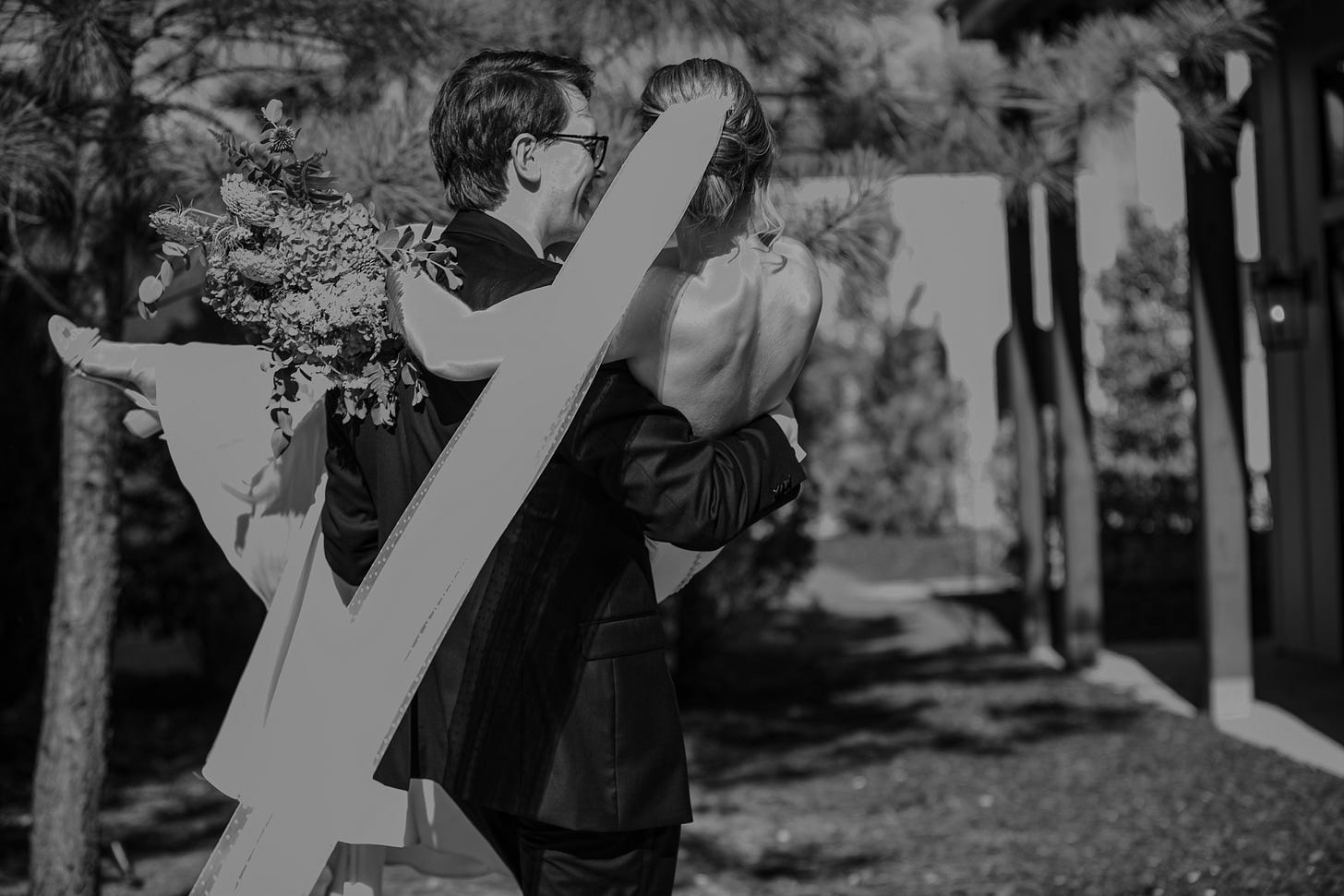husband carrying wife, with flowers in hand