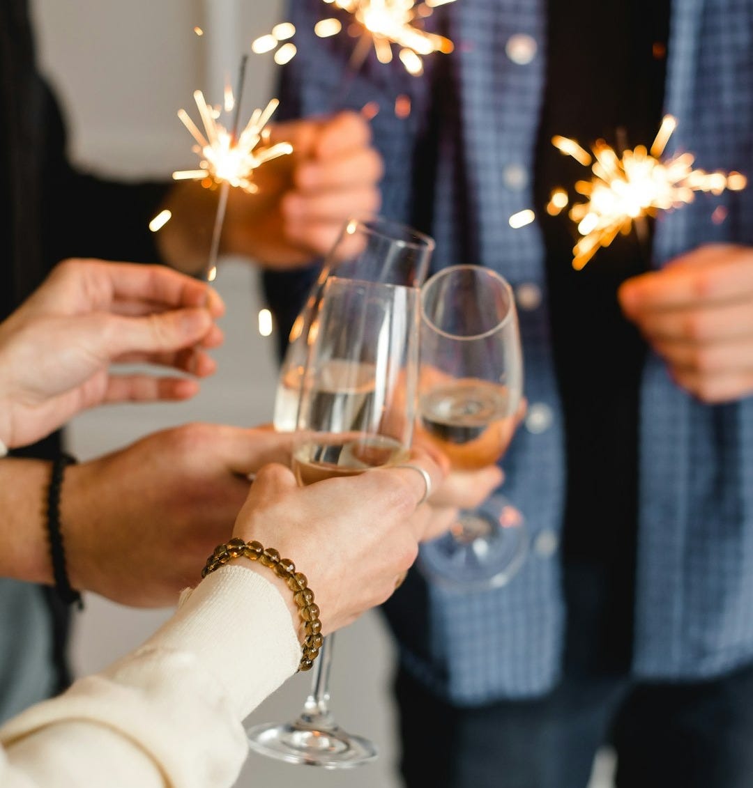 woman in white long sleeve shirt holding clear wine glass