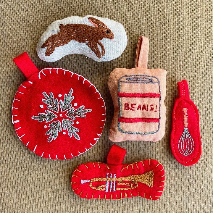 Embroidered Christmas ornaments depicting a bunny, a wreath, a whisk, a trumpet, a can of beans, and an artichoke