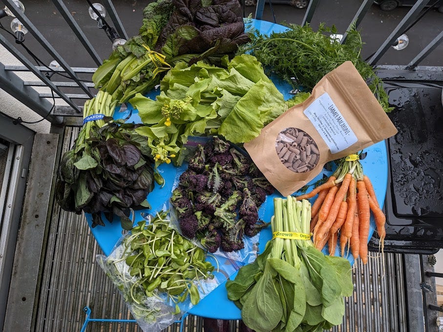 a blue circular table covered in produce and dried artisan pasta