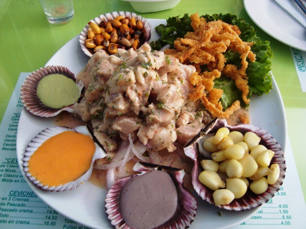 A dish of ceviche, surrounded by sauces and sides served on scallop shells A dish of ceviche, surrounded by sauces and sides served on scallop shells