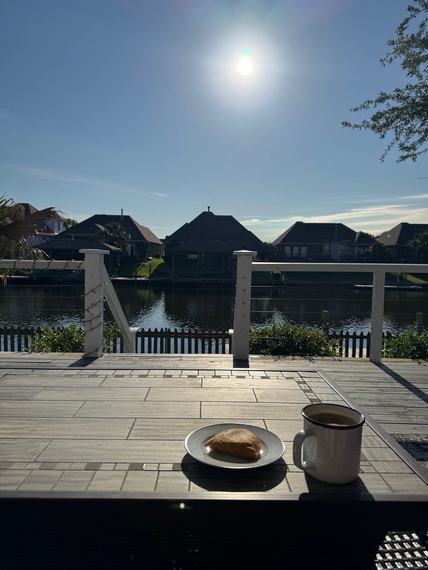 coffee and breakfast pastry on outdoor table facing riverfront coffee and breakfast pastry on outdoor table facing riverfront