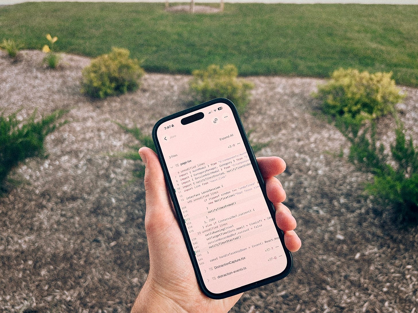 Someone holding an iPhone that is showing a pull request on the Cursor mobile app