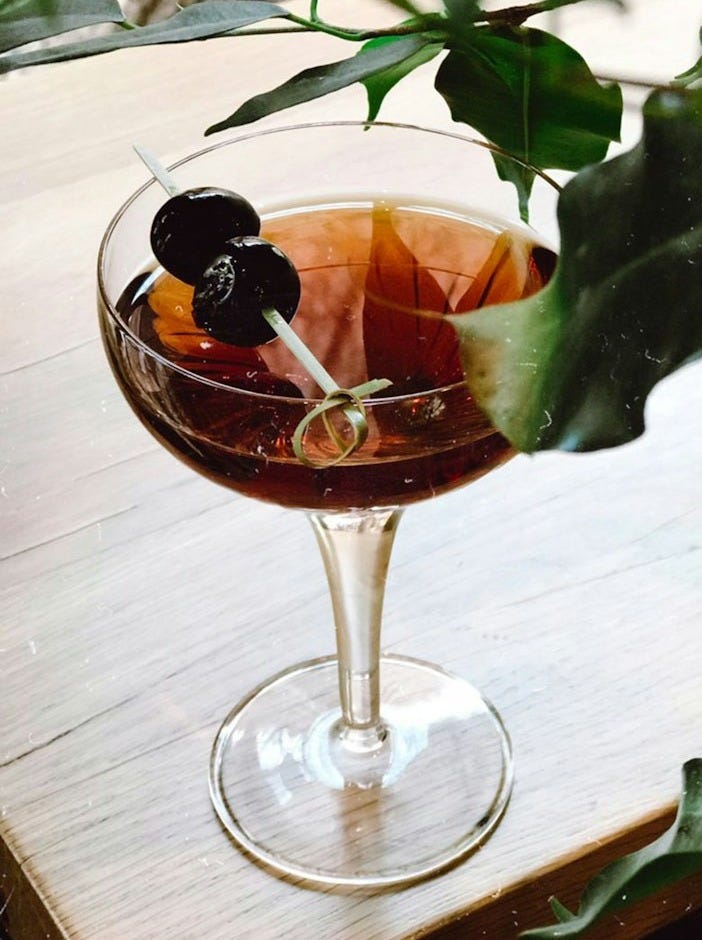 clear wine glass with brown liquid on table