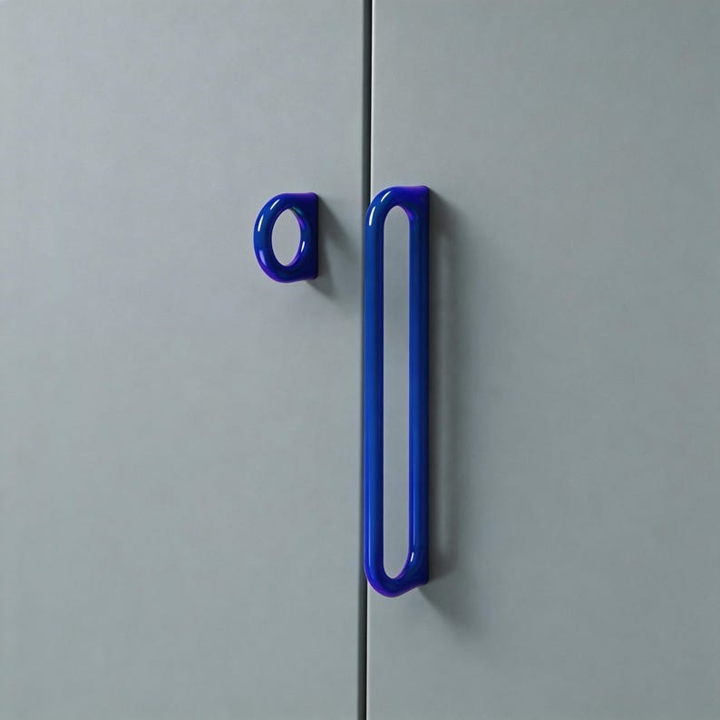 May include: A close-up of a cabinet door with two blue handles. One handle is a small, circular pull, and the other is a long, vertical bar. The handles are a vibrant blue color and are mounted on a light gray cabinet door. May include: A close-up of a cabinet door with two blue handles. One handle is a small, circular pull, and the other is a long, vertical bar. The handles are a vibrant blue color and are mounted on a light gray cabinet door.