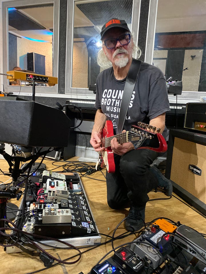 Men and lots of musical equipment in a room