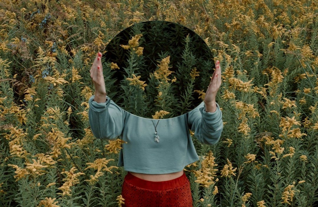 standing woman surrounded by yellow flower field during daytime