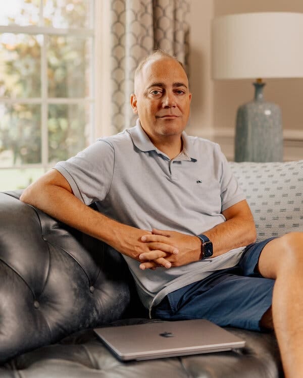 Matt Kaness sitting on a leather couch by a window in his house. Matt Kaness sitting on a leather couch by a window in his house.