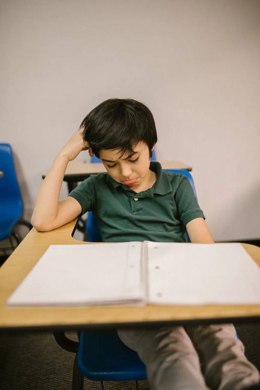 boy sitting on his desk looking lonely boy sitting on his desk looking lonely