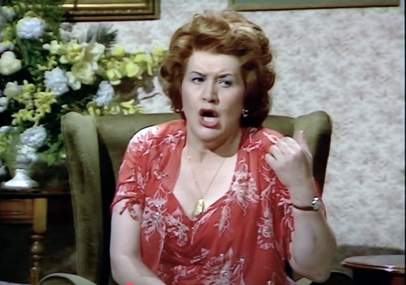 patricia Routledge as Kitty, pontificating in a high-backed chair