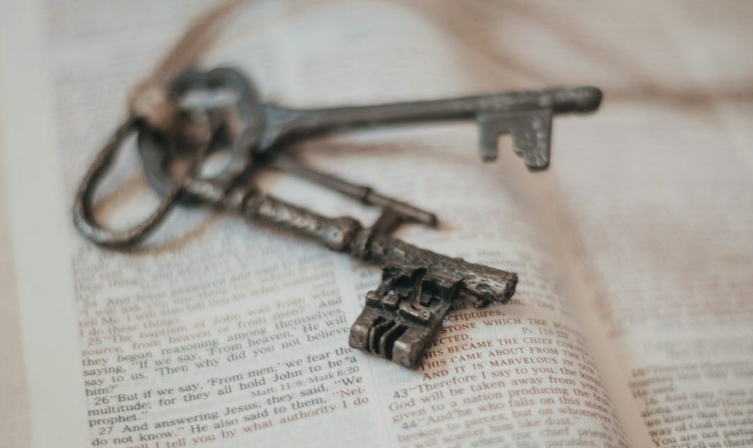 silver skeleton key on book page