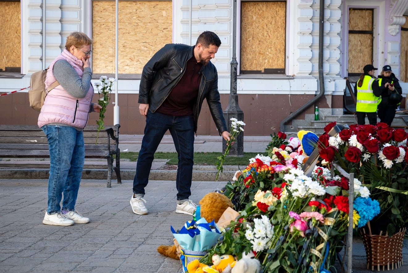 A person and person standing next to a pile of flowers

AI-generated content may be incorrect.