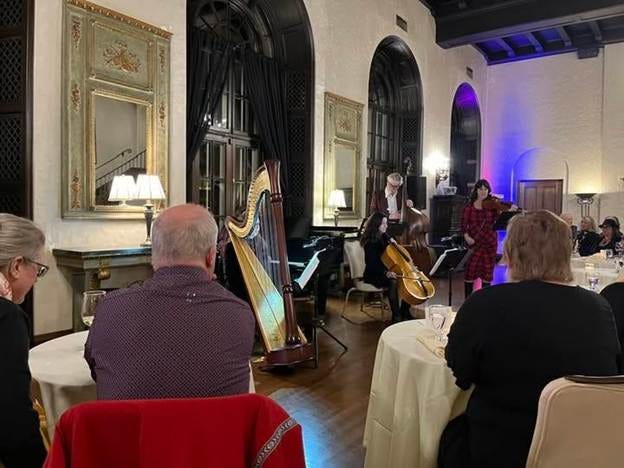 A group of people playing instruments in a room

AI-generated content may be incorrect.