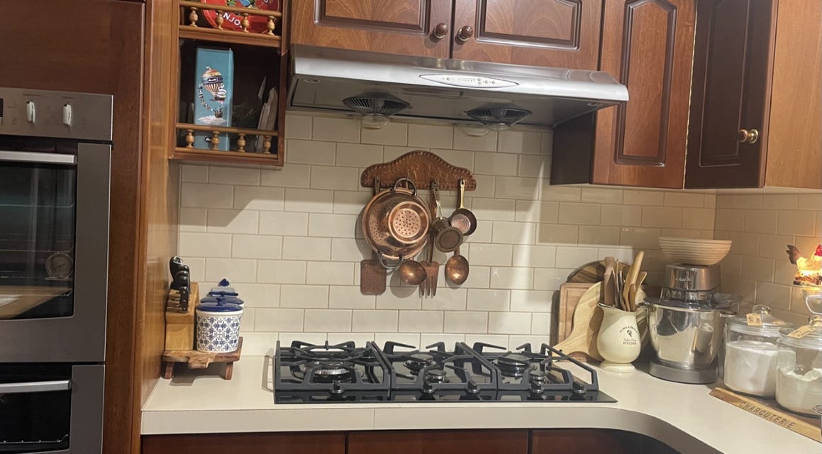 A kitchen with wood cabinets and stove

Description automatically generated