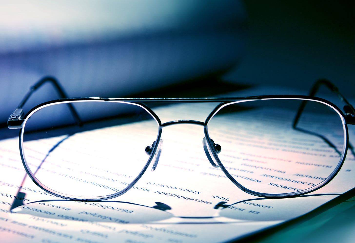 Photo close-up of a pair of glasses sitting on a piece of paper with printed text on it. Photo close-up of a pair of glasses sitting on a piece of paper with printed text on it.