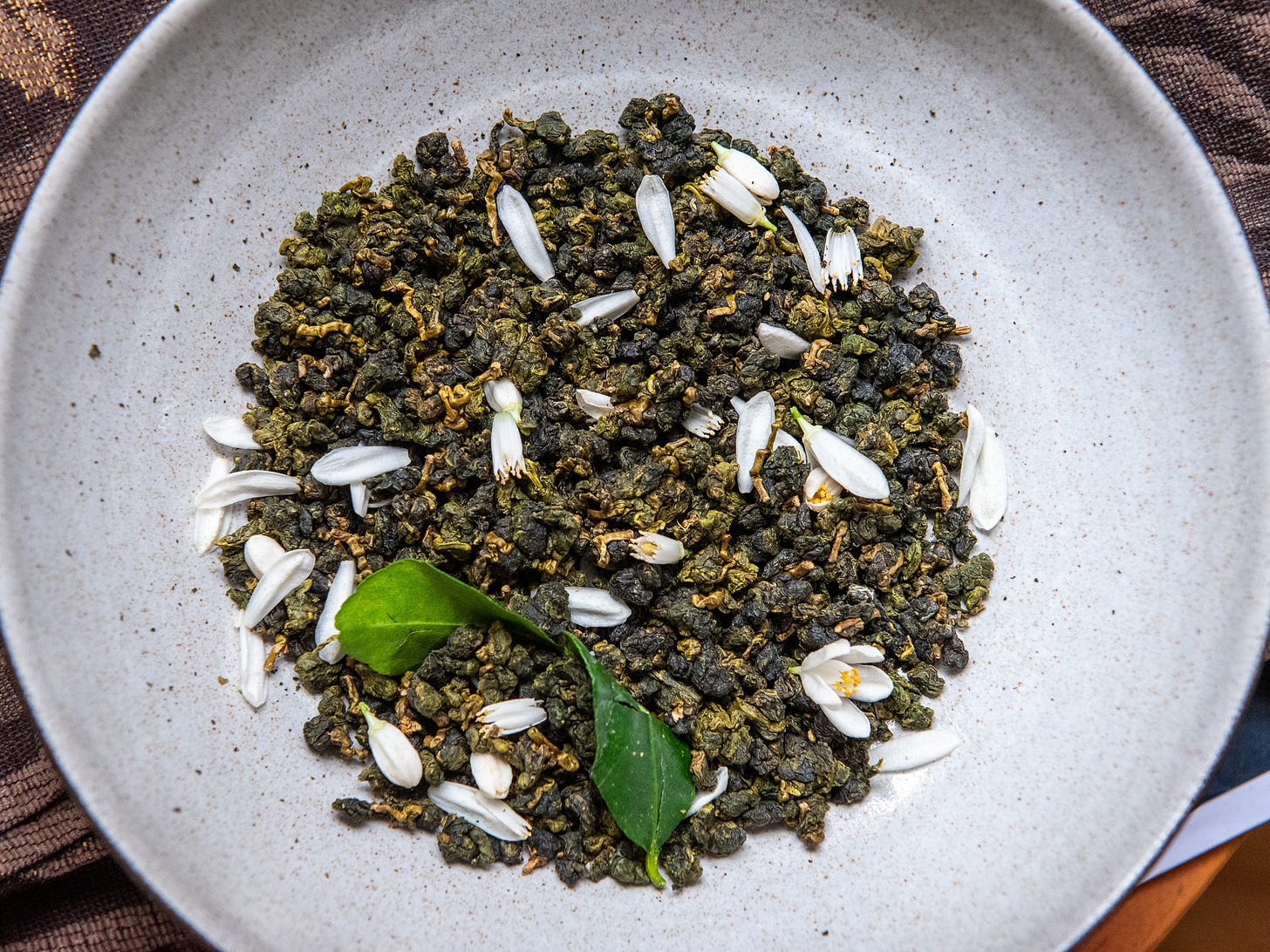 ID: Fresh calamansi flowers and dry oolong tea leaves ID: Fresh calamansi flowers and dry oolong tea leaves