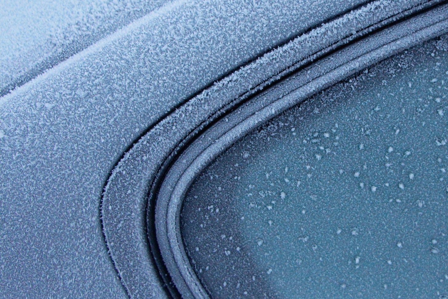 A car side window covered in frost