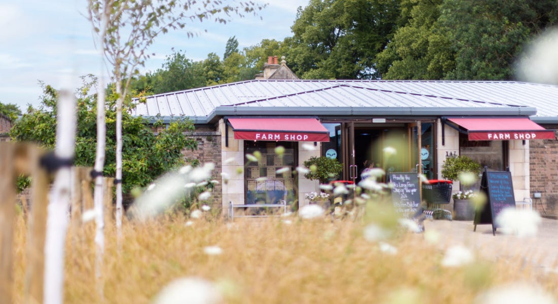 A farm shop exterior with out of focus grass in front of it A farm shop exterior with out of focus grass in front of it