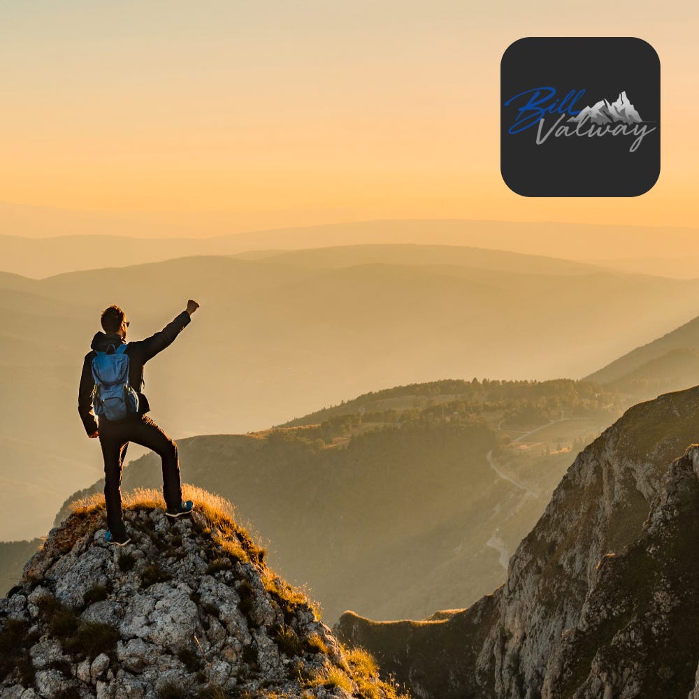 A man stands on a rocky mountain summit at sunrise, fist raised in triumph, overlooking a vast valley — Bill Valway brand hero image representing masculine leadership, personal growth, and building a life worth living
