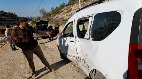 People point at a damaged vehicle, after Israeli forces shot and killed its 17-year-old driver, who the Israeli military said had carried out a car-ramming attack against soldiers, in Hebron, in the Israeli-occupied West Bank December 2, 2025. REUTERS/Mussa Qawasma