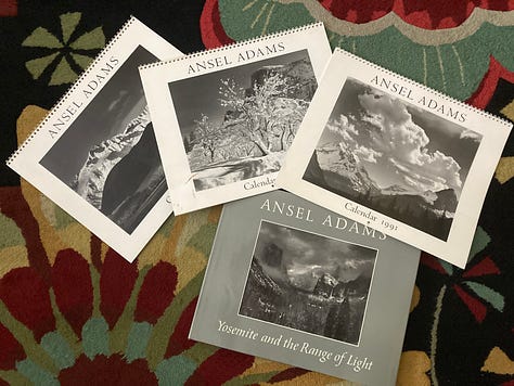 A small collection of Ansel Adams calendars and the book "Yosemite and The Range of Light"