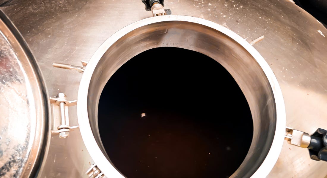 A silver rum container with the door open and rum inside of it A silver rum container with the door open and rum inside of it