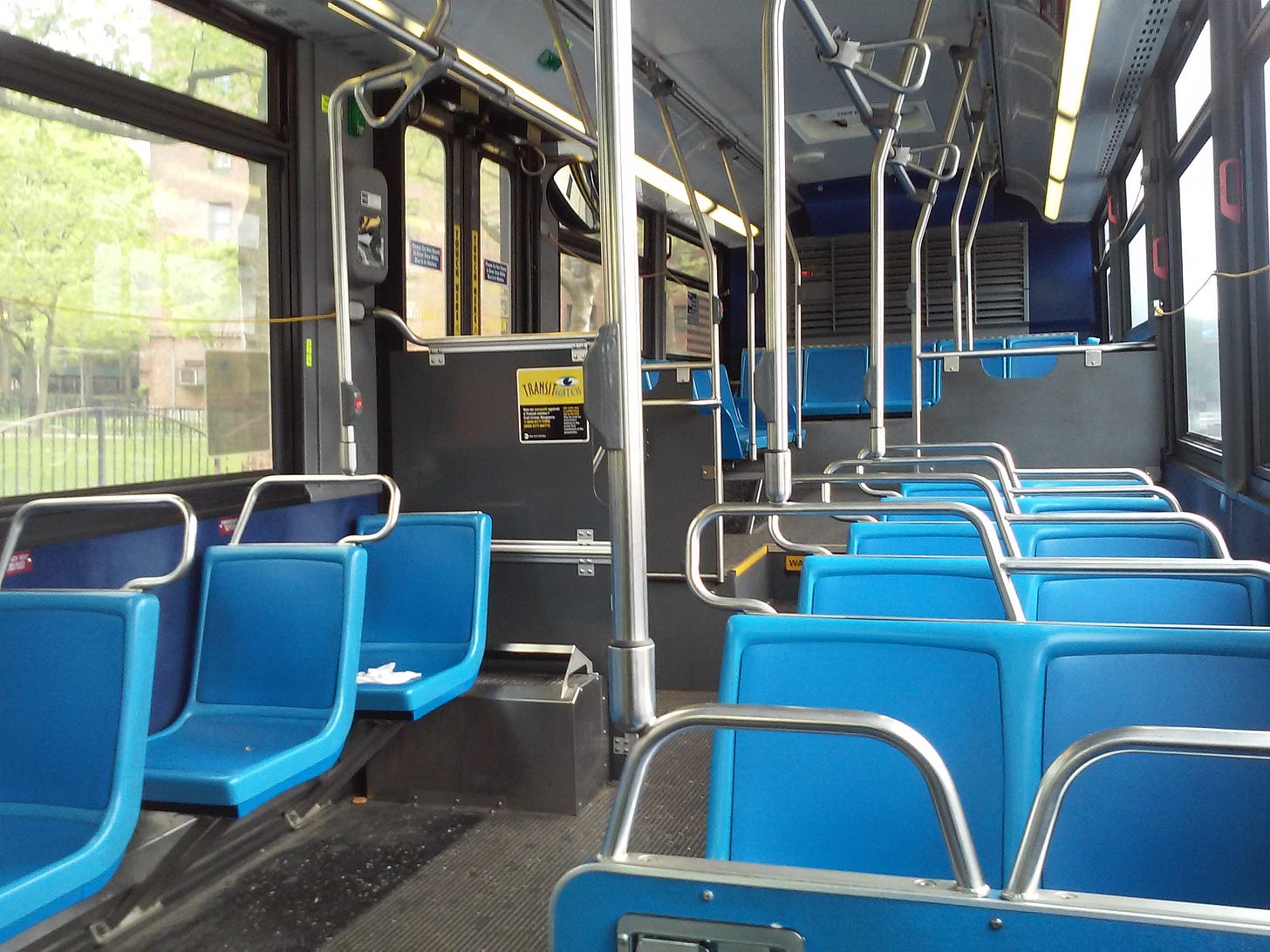 Interior de un Orion VII de Nueva York, con asientos azules y cordones amarillos junto a las ventanillas
