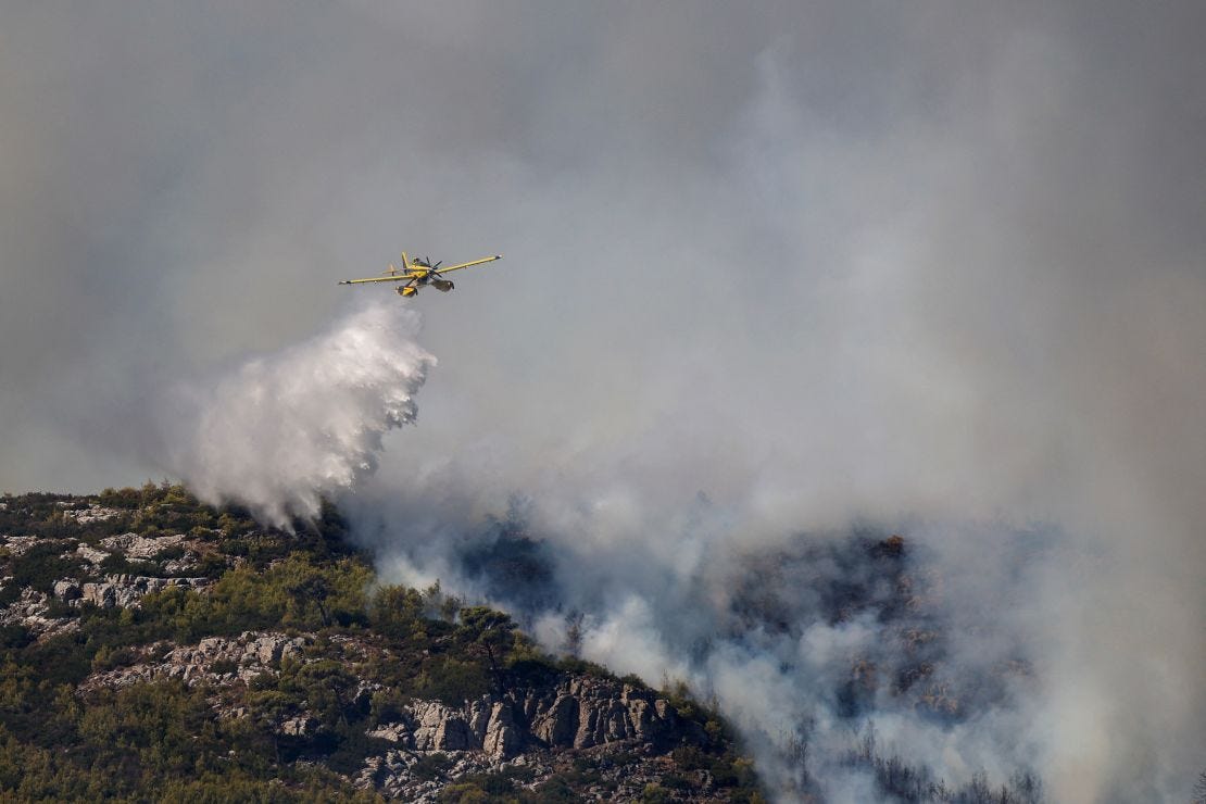 A firefighting plane pours water as a wildfire burns in Grammatiko, near Athens, August 12, 2024. A firefighting plane pours water as a wildfire burns in Grammatiko, near Athens, August 12, 2024.