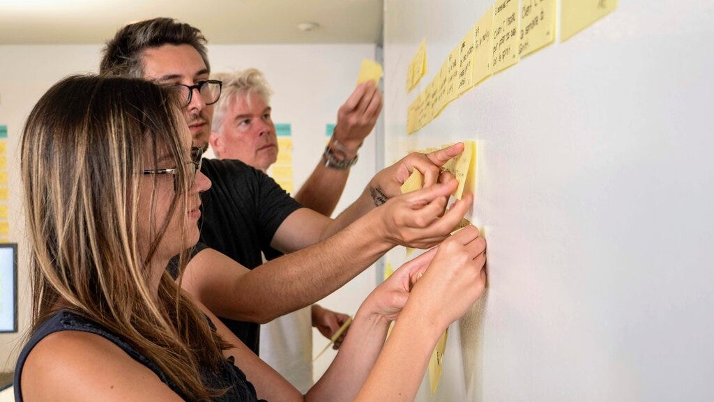 Individuals participating in an experience mapping exercise during a design sprint.